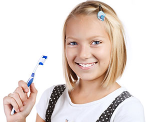 Jan-Blog-Image.  Preteen girl smiling hold a toothbrush