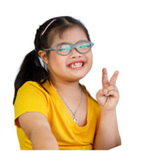 Little girl with glasses smiling and holding up two fingers
